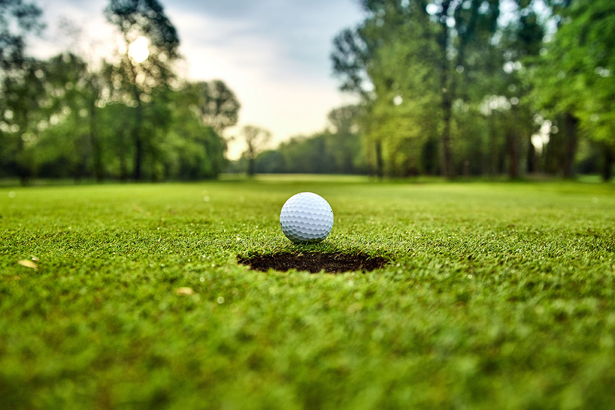 Golf ball on the green. golf ball on lip of cup